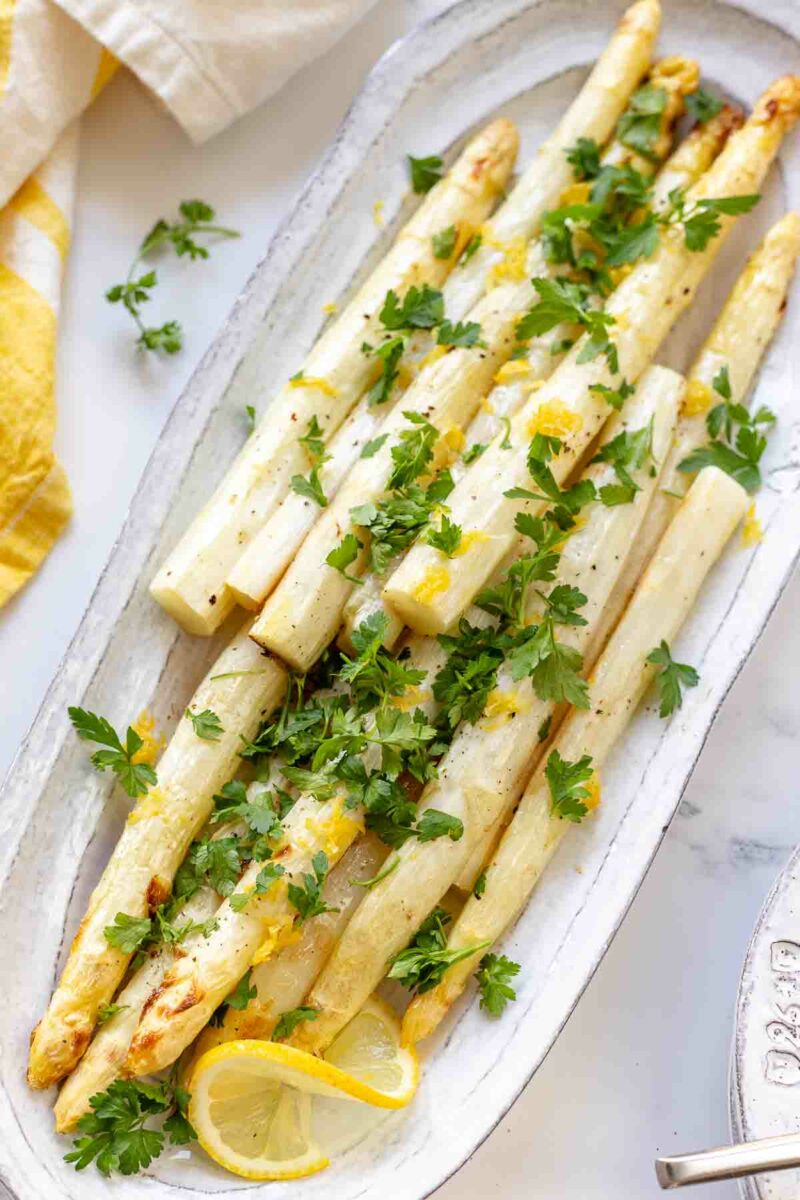 Rezept für gerösteten weißen Spargel im Ofen gebacken mit Olivenöl, Zitronensaft, Zitronenschale und frischer Petersilie.