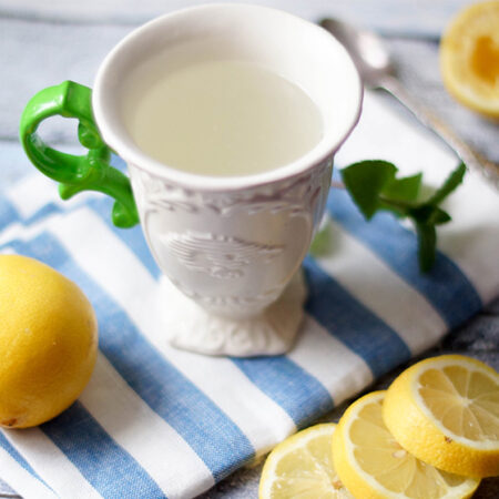 Tasse mit Wasser mit frisch gepresstem Zitronensaft