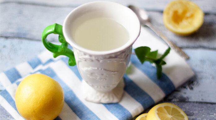 Tasse mit Wasser mit frisch gepresstem Zitronensaft