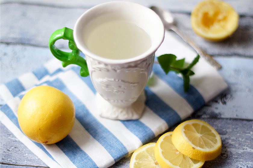 Tasse mit Wasser mit frisch gepresstem Zitronensaft