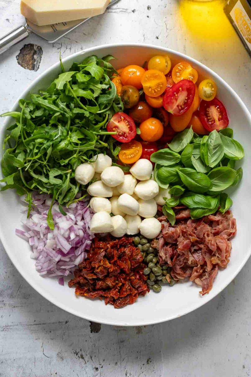 Parmaschinken, Mini‑Mozzarella, Kapern und frischen Tomaten in ein Schüssel