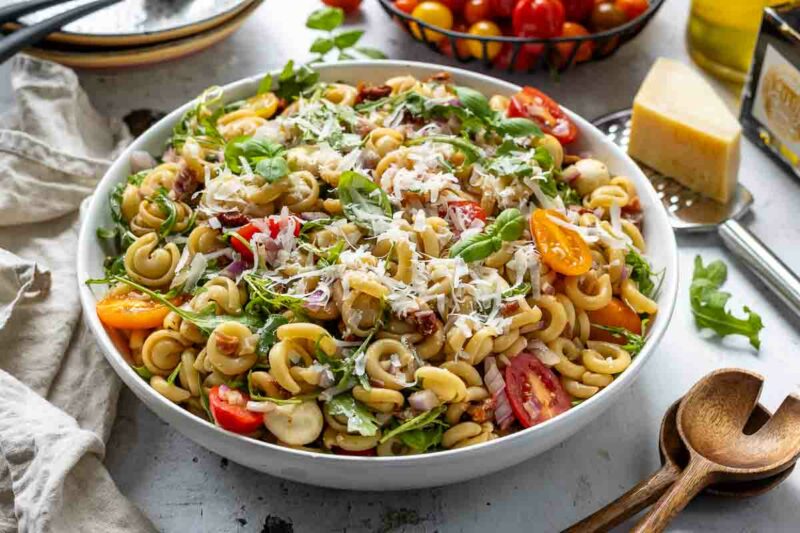 Gesunder mediterraner Nudelsalat mit Vollkornnudeln, Parmaschinken, Mini‑Mozzarella, Kapern und frischen Tomaten 