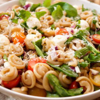 pasta salad with cherry tomatoes, red onion, sun-dried tomatoes, prosciutto, mozzarella, arugula, basil, capers, balsamic...