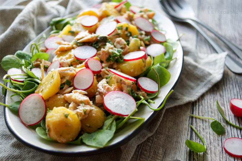 Kartoffelsalat mit Räuchersaibling Rezept. Jungen Kartoffeln, frischem Postelein (Portulak), Kapern, Frühlingszwiebel und Radieschen, mit einem Dressing aus Zitronensaft, Meerrettich, Dill und Olivenöl