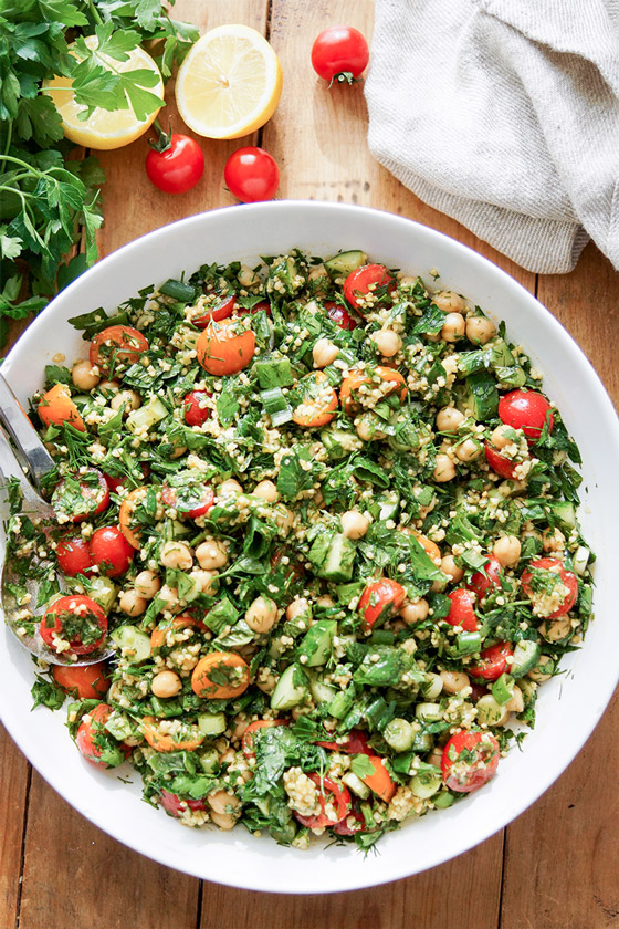 chickpea tabbouleh salad with millet, chickpeas, tomatoes, cucumber, green onions, parsley, dill and mint