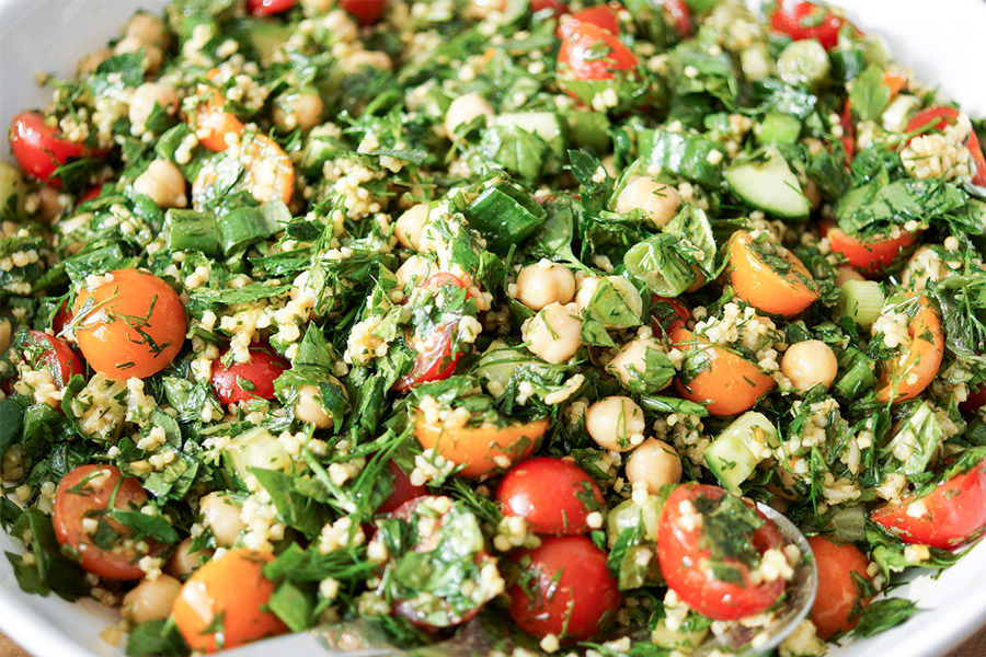 chickpea tabbouleh salad with millet, chickpeas, tomatoes, cucumber, green onions, parsley, dill and mint