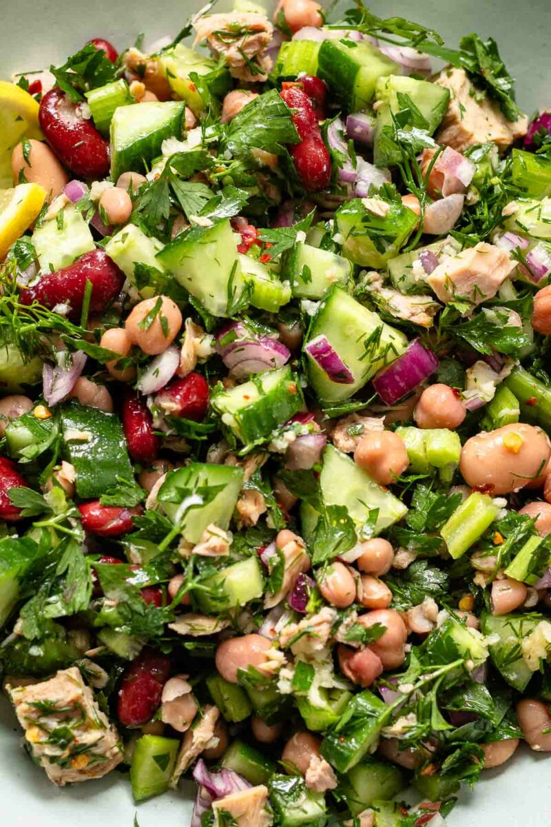 Close Up Mediterranean bean salad with tuna, lemon, garlic, herbs, cucumber and celery.