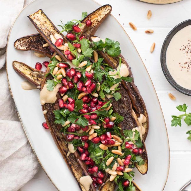 Geröstete japanische Aubergine mit Tahin-Soße, Granatapfel, Pinienkerne, Petersilie