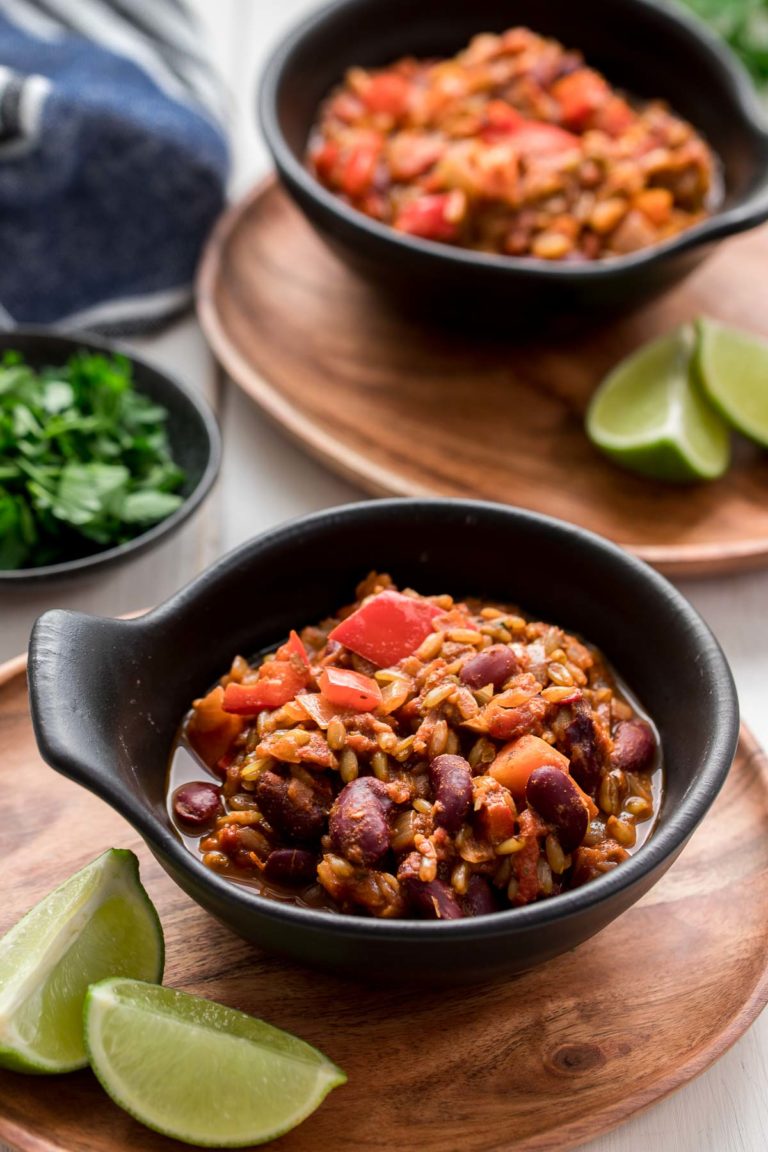 Vegetarisches Chili Rezeppt mit Grünkern (Chili sin Carne) mit Limetten, frische Kräuter serviert