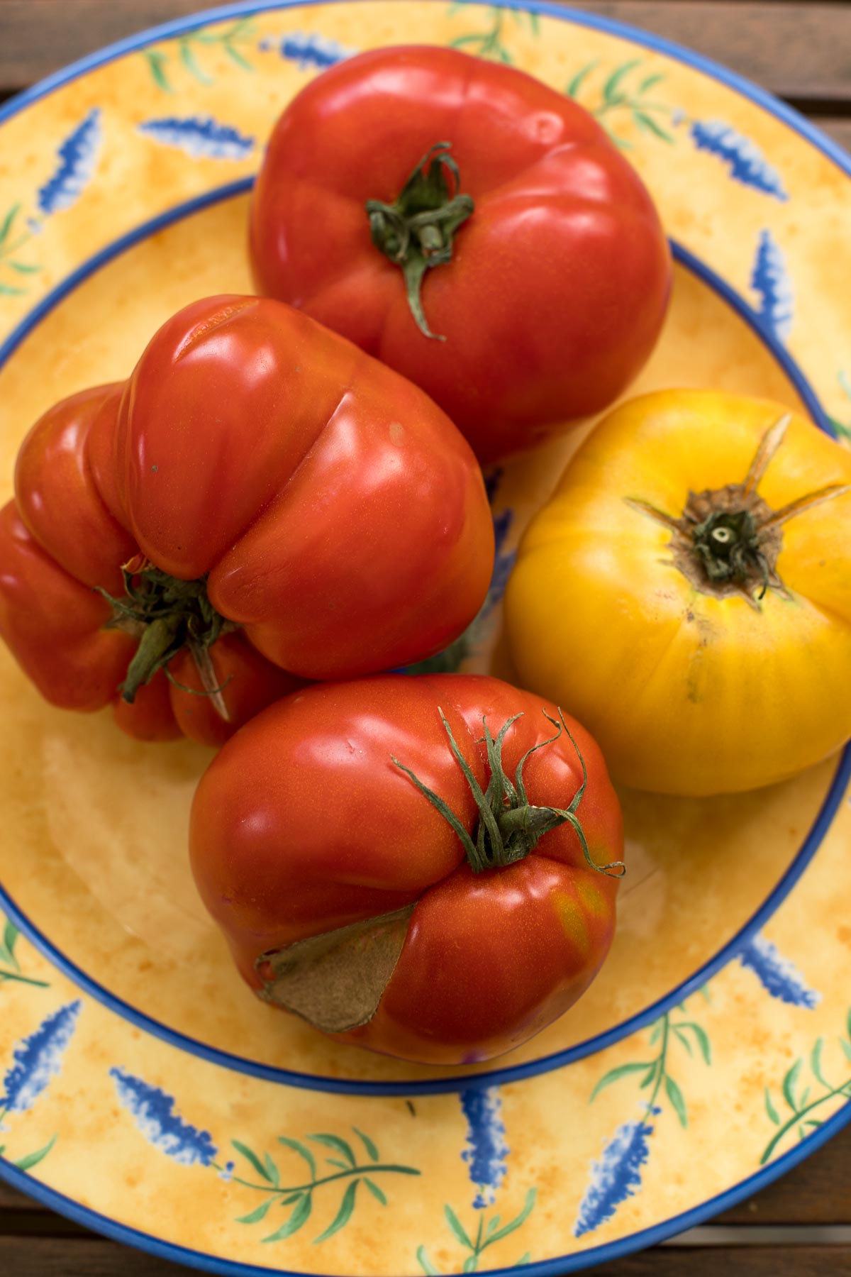 Altesorten Tomaten auf einen Teller für Tomaten-Melonen-Salat mit Parmaschinken und Minze