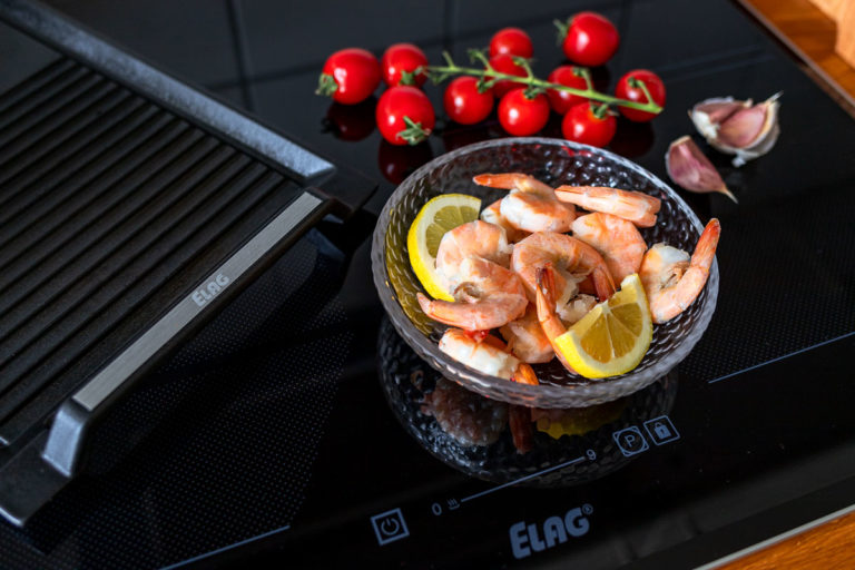 Unboxing ELAG Induktionskochfeld - Garneln, Tomaten, Knoblauch auf dem Herd