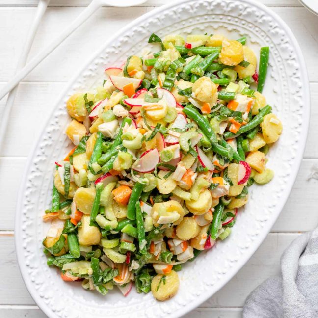 Einfacher Kartoffelsalat mit Surimi, grüne Bohnen, Sellerie und Radieschen in Öl Essig Dressing