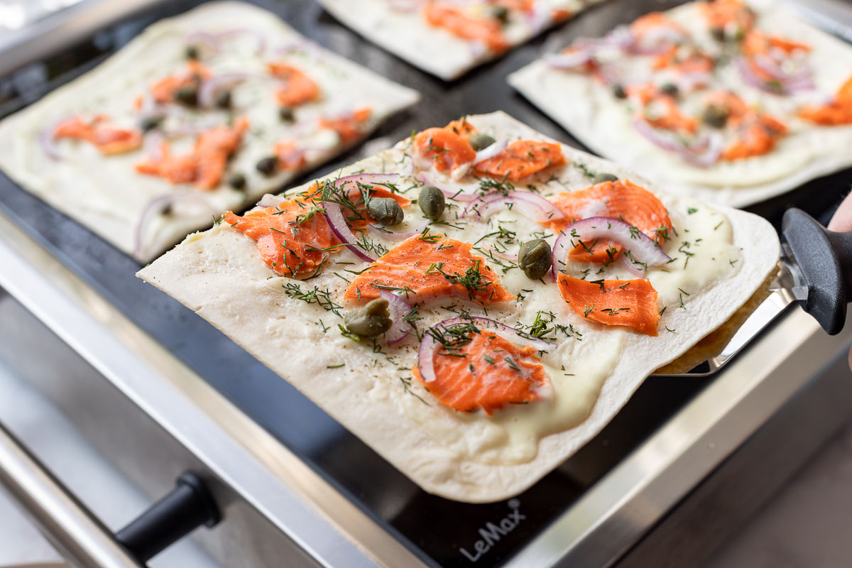 Flammkuchenböden mit crème fraîche, Lachs, Kapern, Dill, Rote Zwiebeln auf LeMax Grill