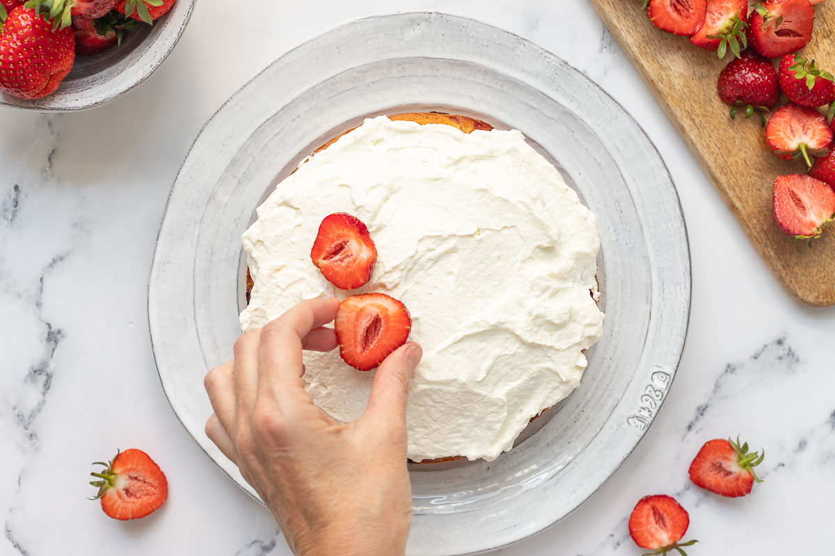 decoriating the cake with strawberries