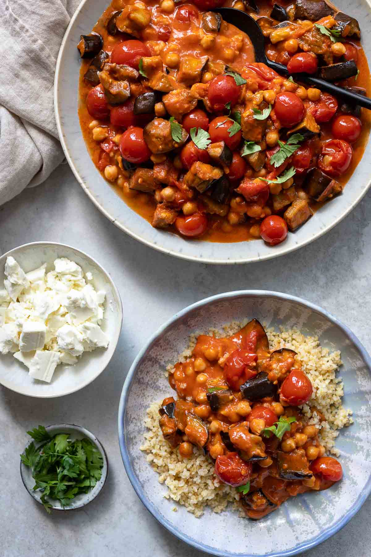 Eggplant and tomato stew with chickpeas, tomato and harissa spice served with bulgur and feta cheese
