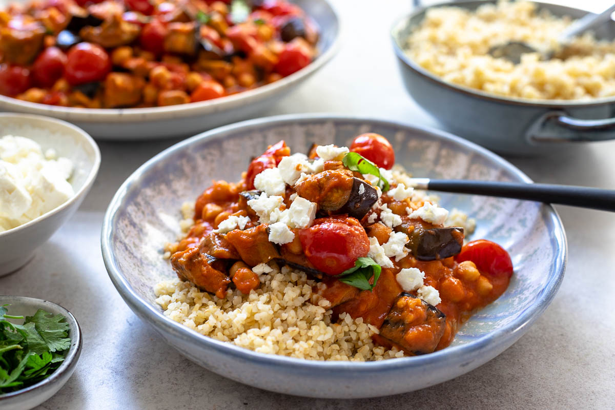 Auberginen-Eintopf Rezept mit Kichererbsen, Tomaten & Harissa mit Bulgur und Feta serviert