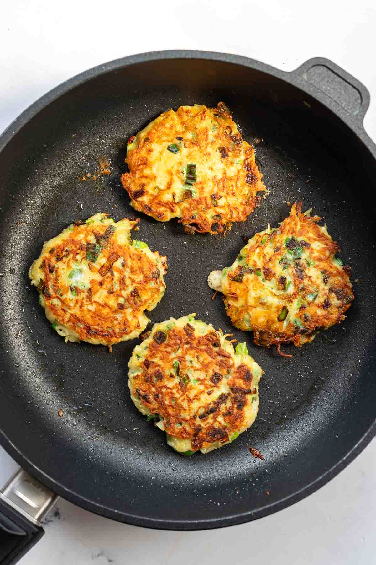 Potato Latkes with Cheese & Green Onion fried in pan
