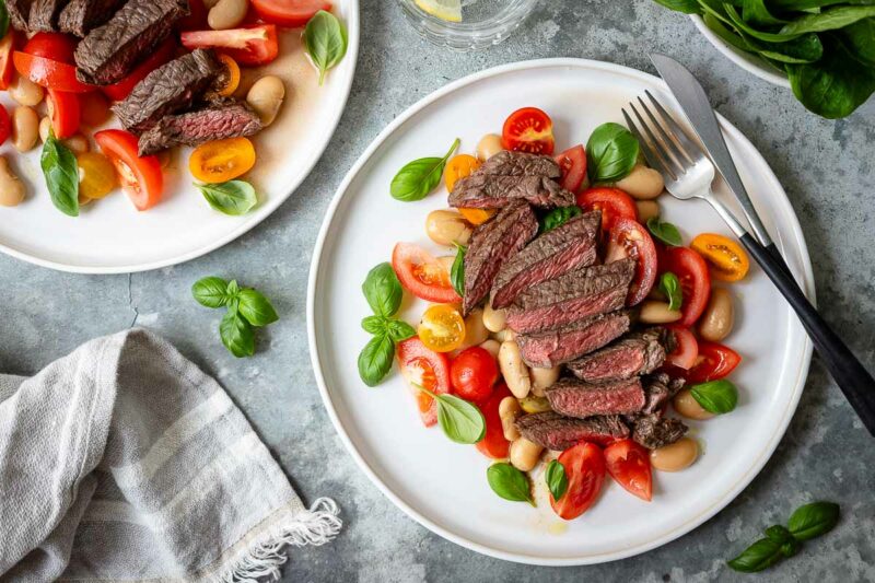 Grilled steak salad with ripe tomatoes, white beans and fresh basil