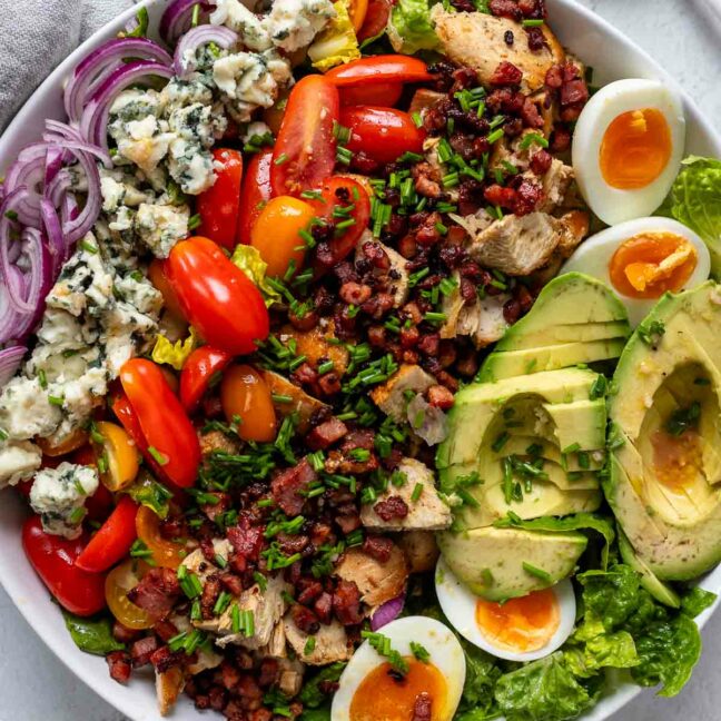 Cobb Salat Rezept mit Romana Salatherzen, gebratenem Hähnchen, knusprigem Speck, cremiger Avocado, Blauschimmelkäse und hart gekochten Eiern