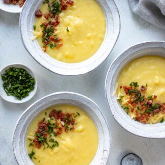 Kartoffel-Käse-Suppe Rezept mit Cheddar, Speck und Schnittlauch serviert in Schüsseln