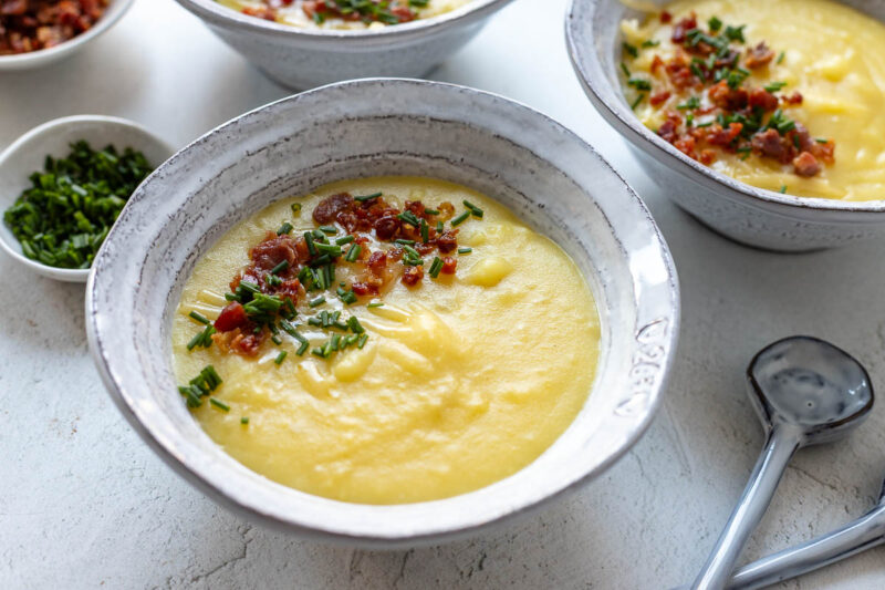 Cheddar Cheese Potato Soup / Kartoffel-Käse-Suppe Rezept mit Cheddar, Speck und Schnittlauch serviert in Schüsseln