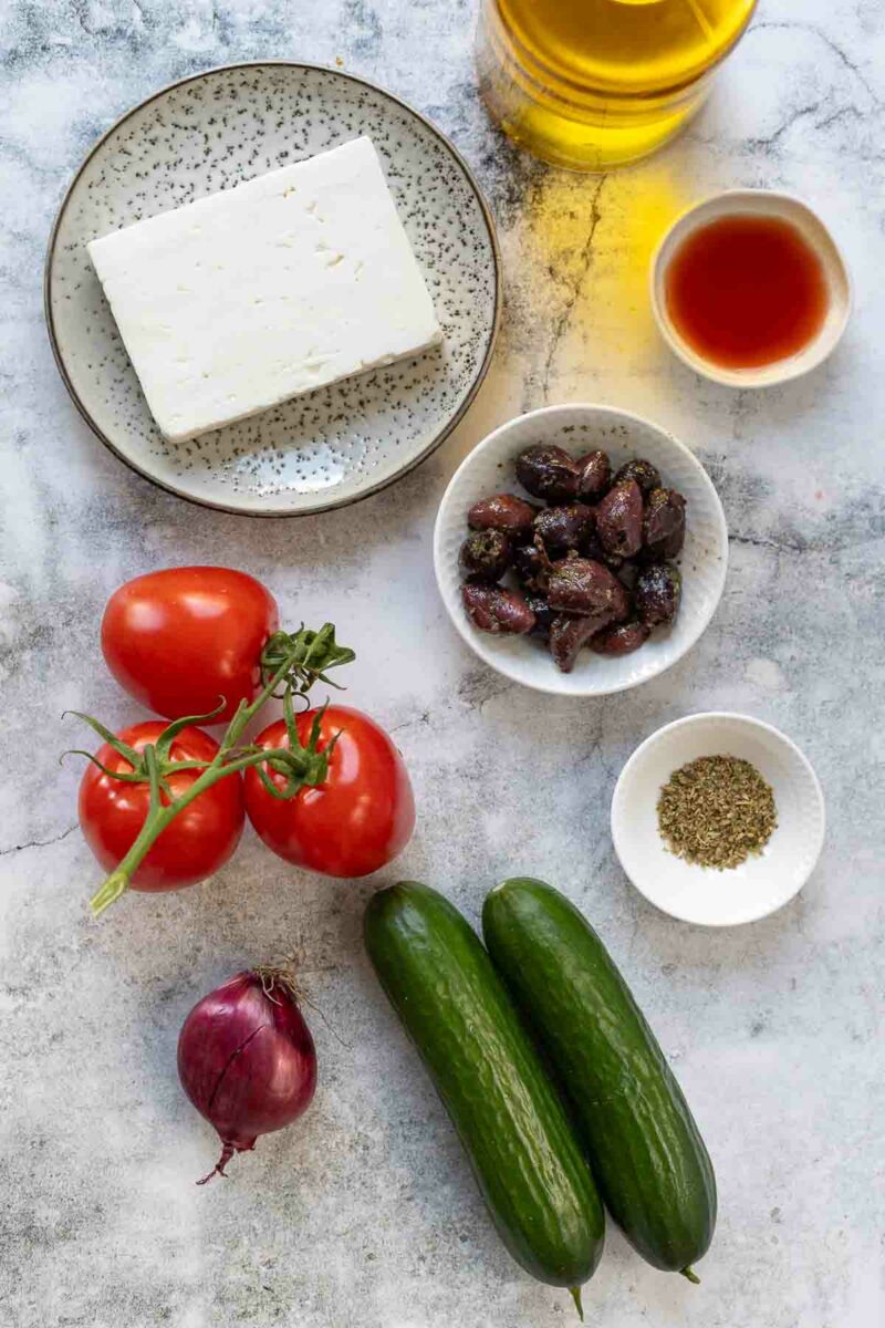 Greek Salad ingredients (tomato, cucumber, onion, olives, oregano, olive oil and red wine vinegar)