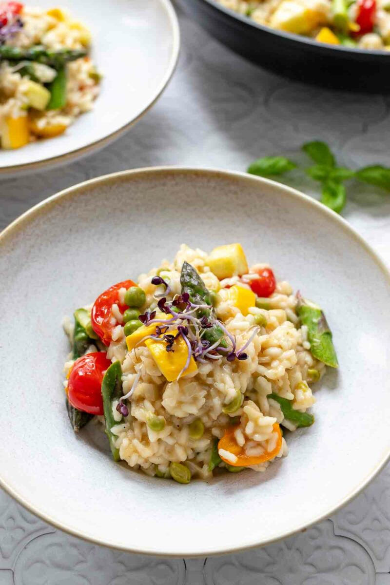 Servierte Gemüserisotto (Risotto Primavera) Rezept mit Spargel, Zucchini, Erbsen und Tomatp