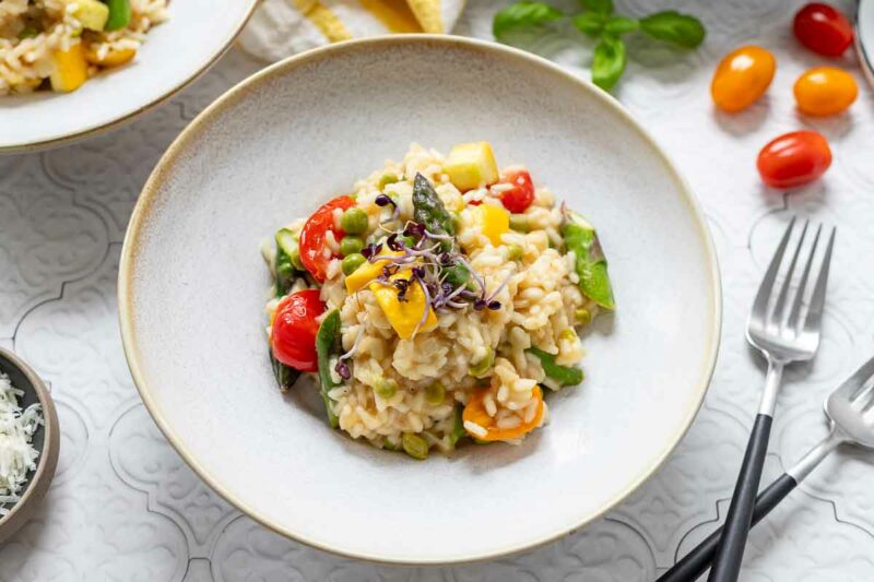 Servierte Gemüserisotto (Risotto Primavera) Rezept mit Spargel, Zucchini, Erbsen und Tomatp