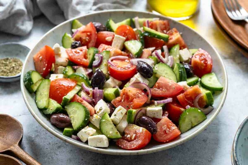 Greek salad recipe made with  tomato, cucumber, onion, olives, oregano, olive oil and red wine vinegar