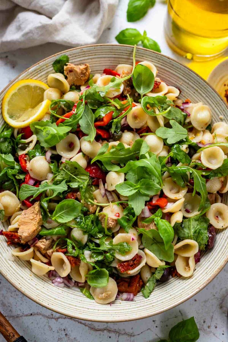 tuna pasta salad recipe with sweet roasted red peppers, sun-dried tomatoes, Kalamata olives, capers and arugula leaves