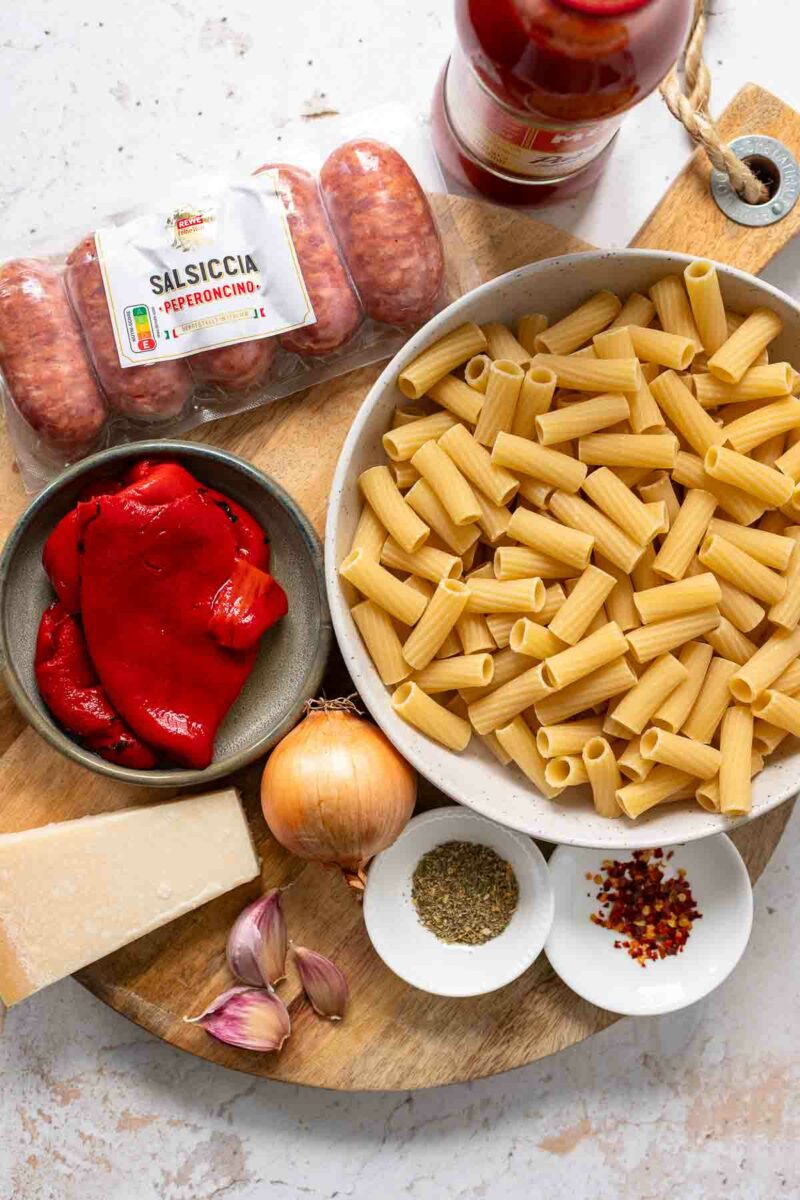 Zutaten für das Pasta-mit-Salsiccia-Rezept in cremiger Tomaten-Paprika-Sauce mit italienischer Wurst, Rigatoni, gerösteter Paprika und Parmesan.