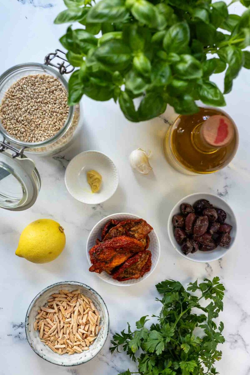 Salat Zutaten: Naturreis, Kraüter, Zitrone, Oliven, Tomaten, Mandeln